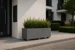 Prostokątna donica betonowa na nóżkach przed budynkiem wielorodzinnym