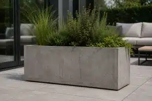 Duża prostokątna donica z betonu architektonicznego z roślinami na nowoczesnym tarasie