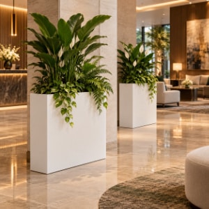 Dwie białe donice z włókna szklanego z zielonymi roślinami ustawione w eleganckim holu hotelowym